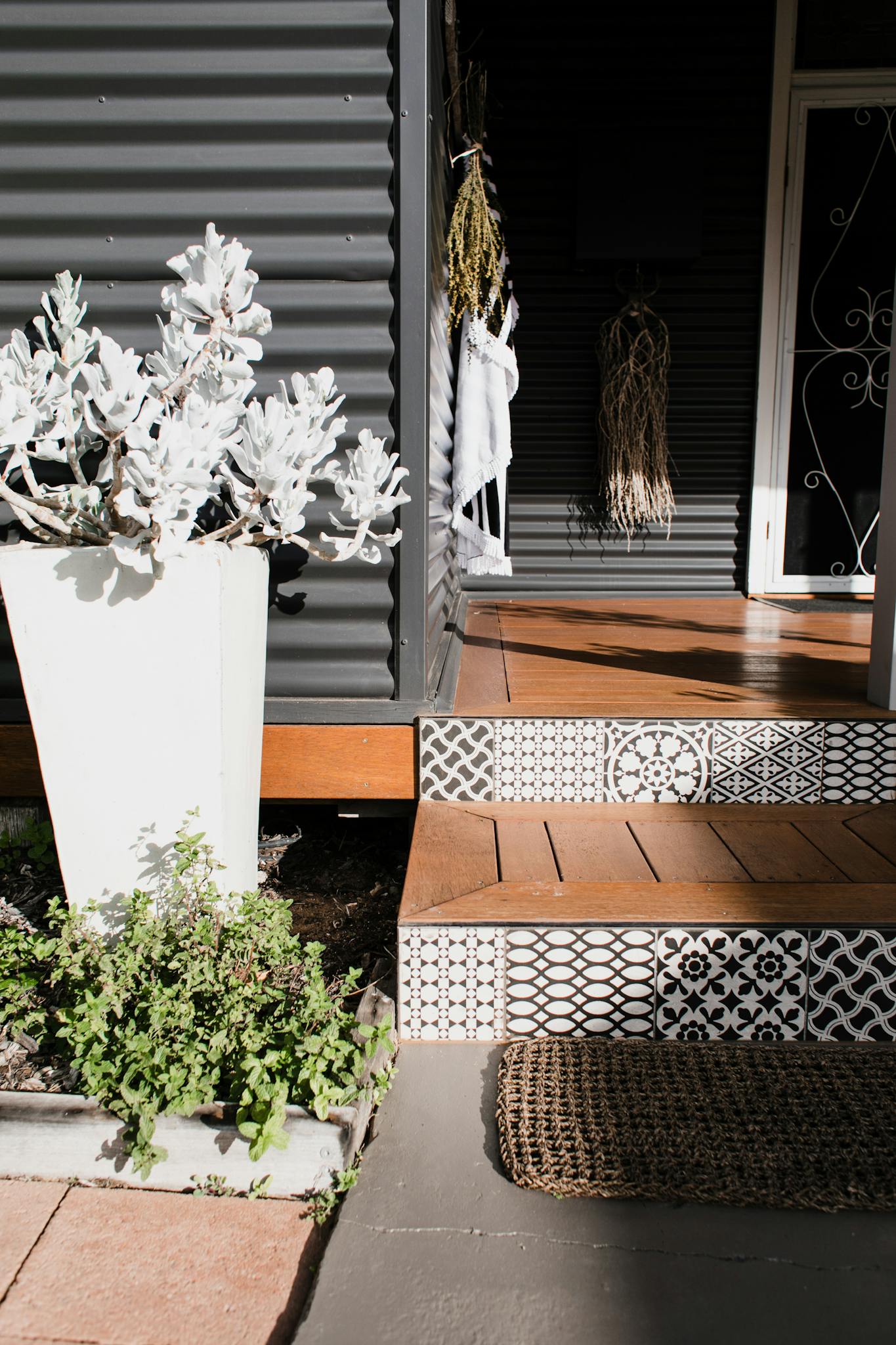 Inviting home entrance featuring potted plants and decorative tiled steps.